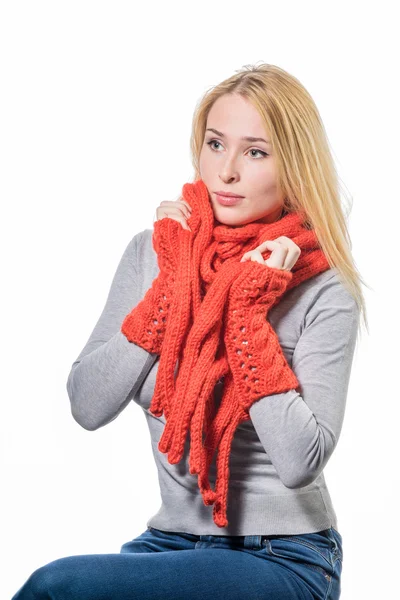 Mulher loira alegre embrulhada calorosamente em um lenço de inverno de lã vermelha isolado no branco — Fotografia de Stock