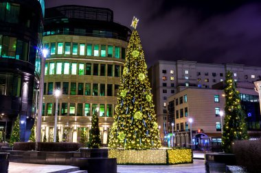 New Year tree and holiday Christmas decorations in the street near metro subway station Belorusskaya at night in Russia, Moscow business center