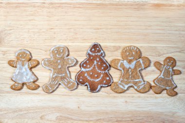 gingerbread homemade figures of four people together with christmas tree in the middle of a group on a wooden board with copy space for your text