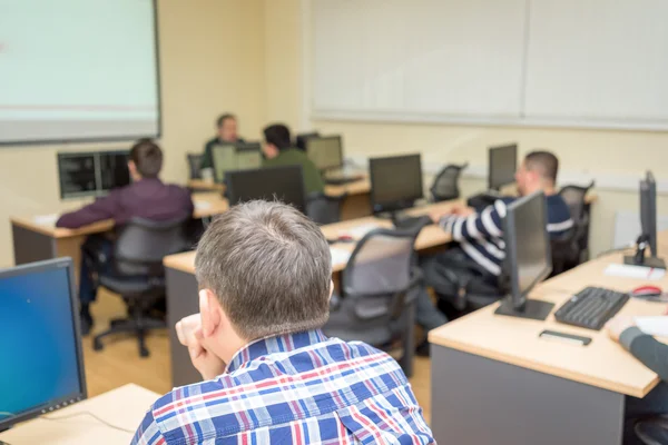 Студенты, работающие в компьютерном классе колледжа — стоковое фото
