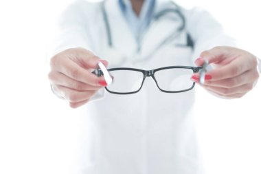 Optometrist elinde gözlük tutuyor.
