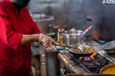 Şef Hint mutfağı yemeği hazırlıyor ve servis ediyor.