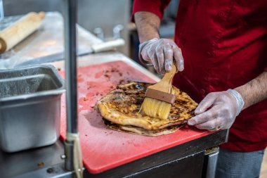 Aşçı lezzetli geleneksel tandır ekmeği yapıyor.