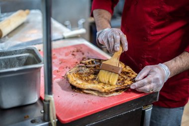 Aşçı lezzetli geleneksel tandır ekmeği yapıyor.