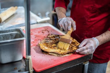 Aşçı lezzetli geleneksel tandır ekmeği yapıyor.