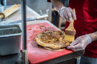 Aşçı lezzetli geleneksel tandır ekmeği yapıyor.