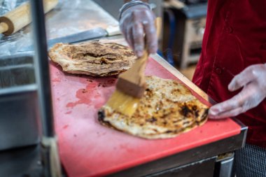Aşçı lezzetli geleneksel tandır ekmeği yapıyor.