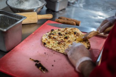 Aşçı lezzetli geleneksel tandır ekmeği yapıyor.