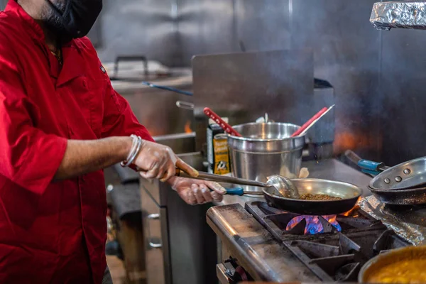 Şef Hint mutfağı yemeği hazırlıyor ve servis ediyor.