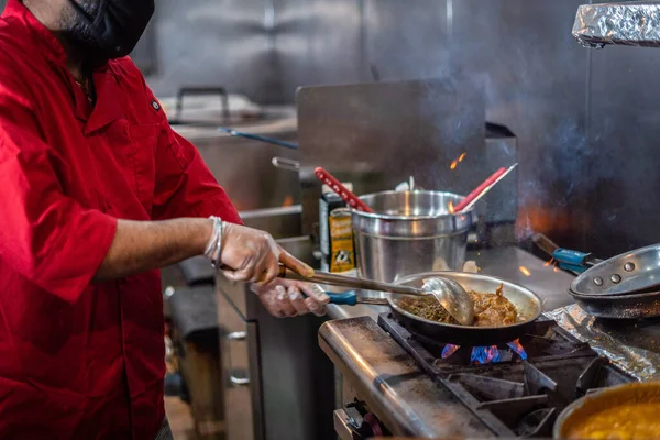 Chef preparing cooking and serving indian cuisine style dish