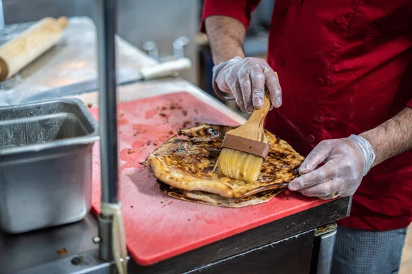 Aşçı lezzetli geleneksel tandır ekmeği yapıyor.