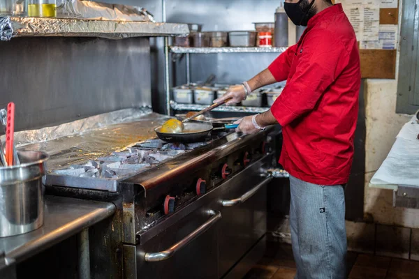 Şef Hint mutfağı yemeği hazırlıyor ve servis ediyor.