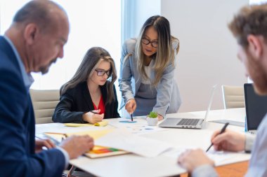 Ofis çalışanı ekibiyle toplantı yapıyor.