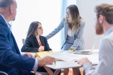 Ofis çalışanı ekibiyle toplantı yapıyor.