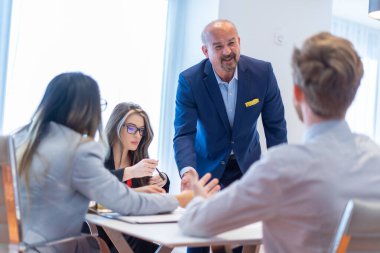 Ofis çalışanı ekibiyle toplantı yapıyor.