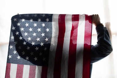 Amerikan bayrağı ve bir adamın silüeti
