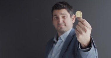 Elinde altın bir Bitcoin tutan bir adam