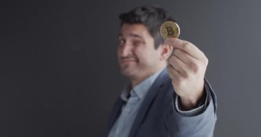 Elinde altın bir Bitcoin tutan bir adam
