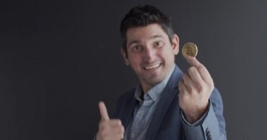 Elinde altın bir Bitcoin tutan bir adam