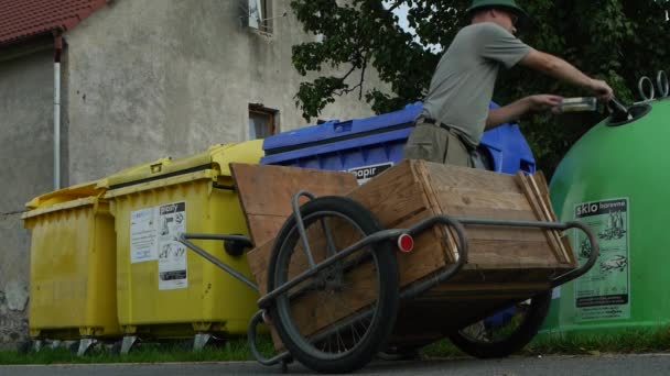 Mann wirft Glasflaschen in Container — Stockvideo