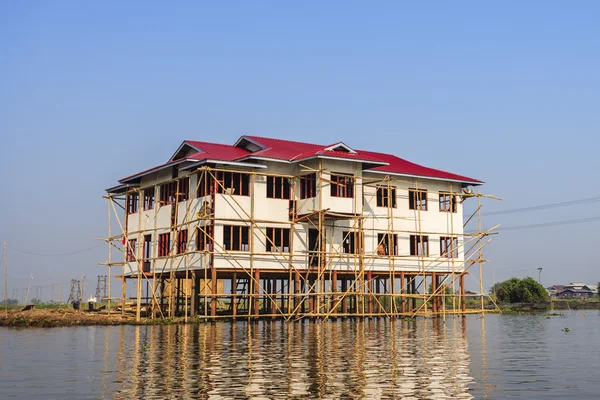 As pessoas locais estão em um barco de cauda longa na frente da aldeia flutuante em Inle Lake — Fotografia de Stock