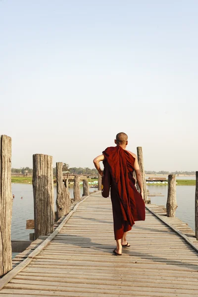 Mandalay, myanmar - 14. Februar: myanmarische Mönche gehen auf der U-bein-Brücke, wo sich die älteste und längste Teakholzbrücke der Welt befindet — Stockfoto