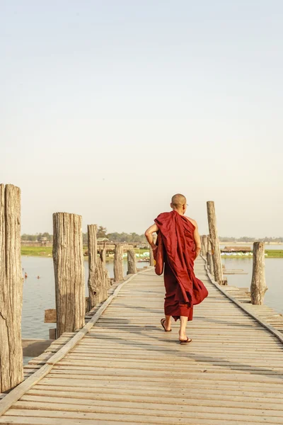 MANDALAY, MIANMAR - FEB 14: Monges de Mianmar caminham na Ponte U Bein, onde é a mais antiga e mais longa ponte de madeira de teca do mundo — Fotografia de Stock