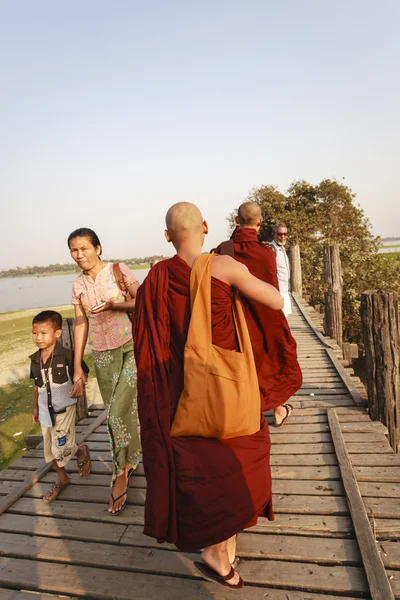 MANDALAY, MIANMAR - FEB 14: Monges de Mianmar caminham na Ponte U Bein, onde é a mais antiga e mais longa ponte de madeira de teca do mundo — Fotografia de Stock