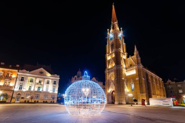 Novi Sad, Sırbistan 05 Ocak 2021: Sırbistan 'ın Novi Sad kentinde noel ışıklarıyla şehir merkezindeki Kutsal Mary kilisesi simgesi.