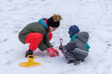 Erkek ve kız kardeş karda oynuyorlar.