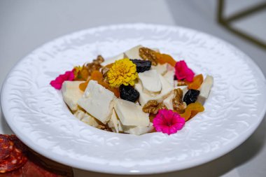 Ceviz ve incirli bir tabak peynir. 