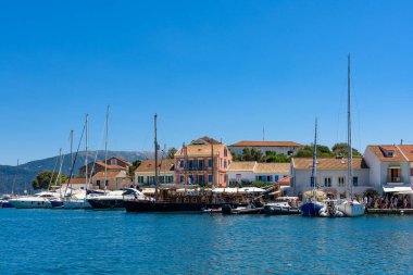 Fiskardo, Yunanistan - 11 Ağustos 2025: Yunanistan 'ın İyon adaları Kefalonya' daki Fiskardo rıhtımı boyunca tekne ve yatlar.