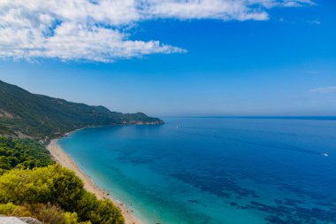 Yunanistan 'da açık mavi bir günde güneşli deniz kıyısına yakın uçurumlar. Turkuaz suyu ve açık mavi gökyüzü olan Pefkoulia plajı, Lefkada adası, İyon deniz kıyısı.