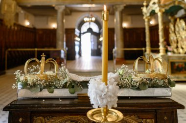 Kilise düğünü için iki taç ve bir mum.