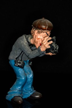 Fotoğraf ekipmanlı yaşlı bir fotoğrafçının seramik figürü.