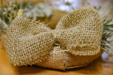 Hediye ambalajının şenlikli dekorasyonu için çuval bezi düğümünden kırsal yay.