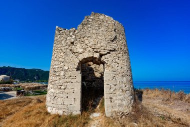 Agios Ioannis sahilindeki eski yel değirmeni, Lefkada, Yunanistan. Yel değirmeninin yıkıntısı.