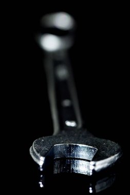 Siyah camdaki İngiliz anahtarının yakın çekimi.