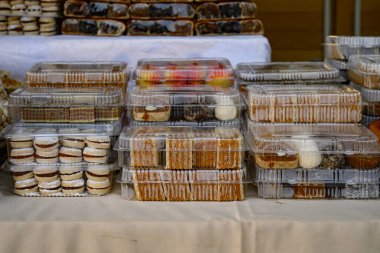 Bir markette satılık plastik kaplarda paketlenmiş çeşitli bisküvi ve hamur işleri..