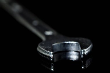 Siyah camdaki İngiliz anahtarının yakın çekimi.