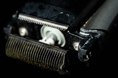 Koyu arkaplanda elektrikli tıraş makinesi.