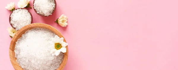 Spa yassı kompozisyonu. Kavanozlarda deniz tuzu, pembe arka planda çiçek. Kopyalama alanı, üst görünüm, afiş. Evde bakım kavramı, rahatla ve dinlen..