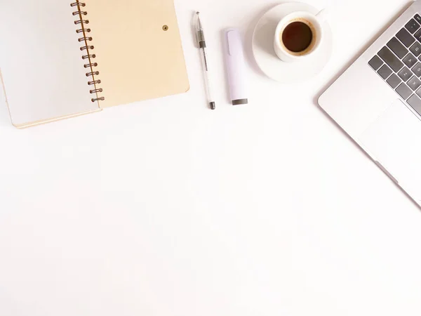 Düz konum dizüstü bilgisayar, kahve, kalem ve defter beyaz masaüstünde. Kopyalama. Uzaktan çalışmayı ve evde çalışmayı kabul et, tele-çalışma, serbest çalışma, karantina. Çevrimiçi öğrenme mesafesi