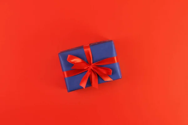 Kırmızı arka planda noel hediyesi. Tatil atmosferi, yeni yıl kutlamaları, tebrik kartları. Düz çizgi, üst görünüm, çerçeve, kopyalanma alanı.