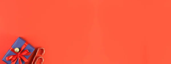 Kırmızı arka planda noel süsü. Tatil atmosferi, yeni yıl kutlamaları, tebrik kartları. Düz çizgi, üst görünüm, çerçeve, telif alanı, pankart.