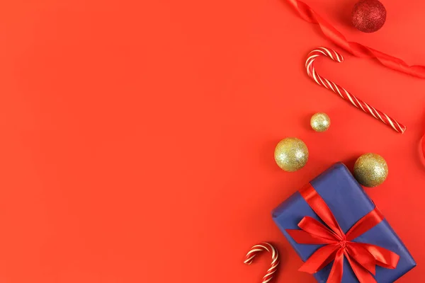 手は赤い背景にクリスマスの贈り物を保持します コンセプト休日の雰囲気 お祝い グリーティングカード フラットレイ上からの眺め — ストック写真
