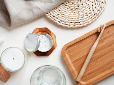 Doğal macun ve bej pamuklu havluyla bambu diş fırçası, beyaz arka planda mum. Çevre dostu kavramı, kopyalama, sıfır atık.