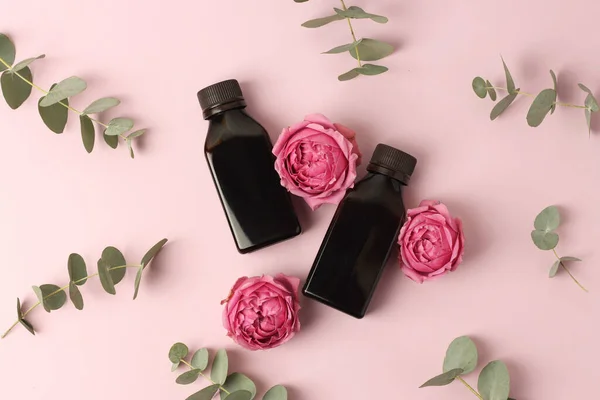 Losyonlu yumuşak bez, pembe arka planda çiçekler. Güzellik kavramı doğal vitamin kozmetik ürünü, cilt bakımı, üst görünüm..