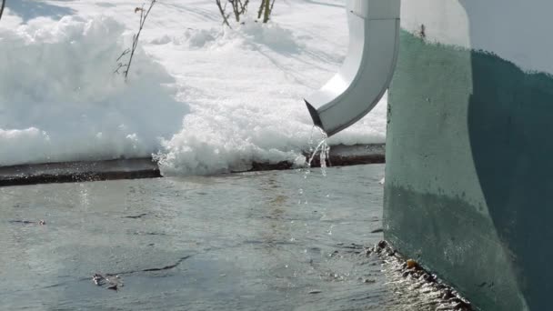 Woda topnieje z rury odpływowej, a krople wody spadają z góry. — Wideo stockowe