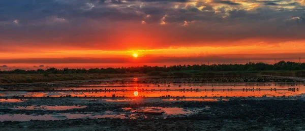 Dawn over the developed salty and therapeutic mud lake. The water reflects the sky and the sun